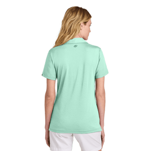 Back of model wearing women's TravisMathew mint polo with Insideya Golf icon on back yoke
